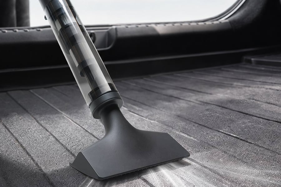 Xiaomi Mijia Car Vacuum Cleaner cleaning the floor of a vehicle trunk area.